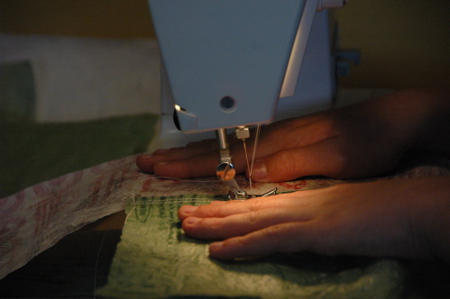 Eli guides fabric in the machine